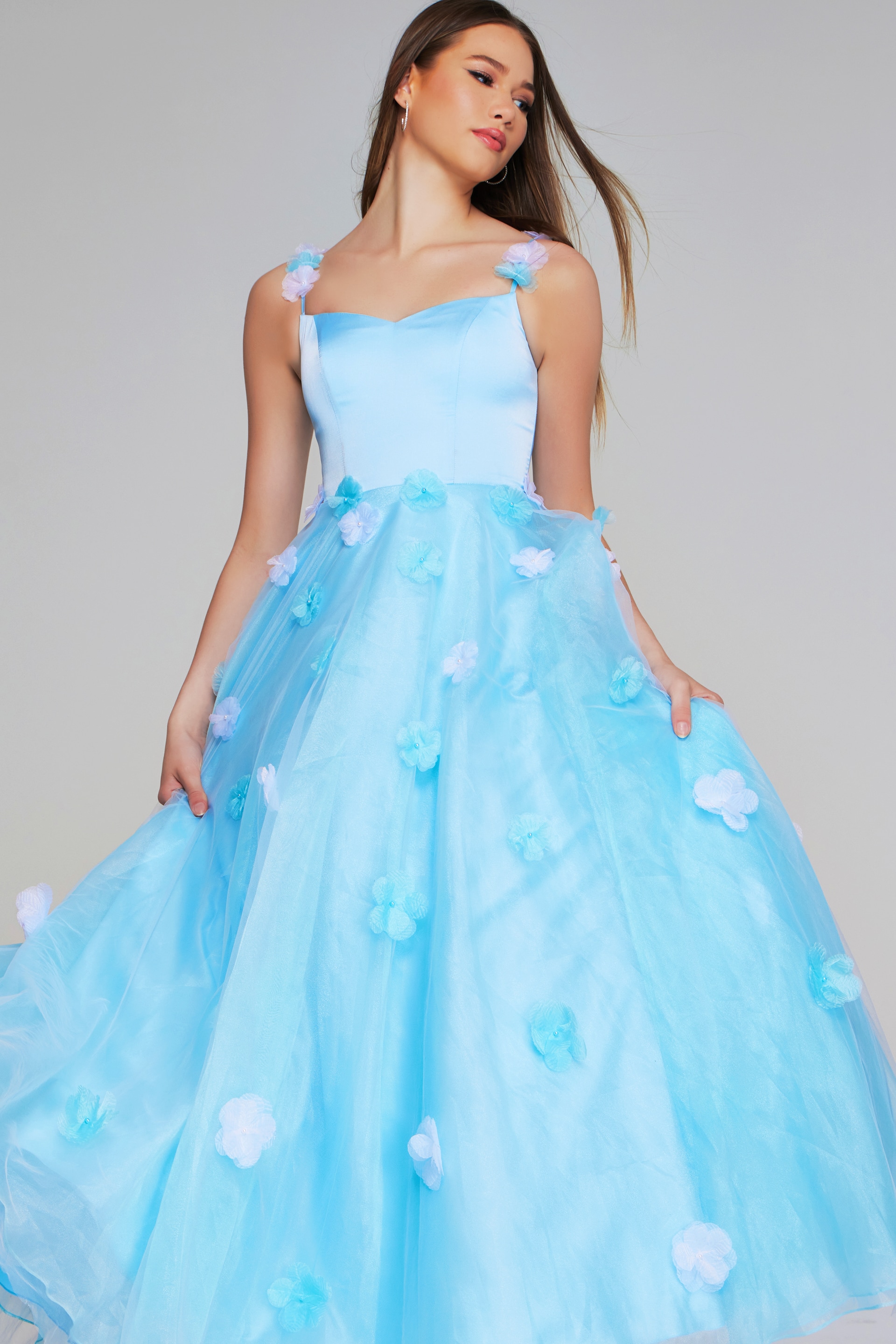 Model wearing Jovani K25988 light blue gown with floral appliques, full front view.
