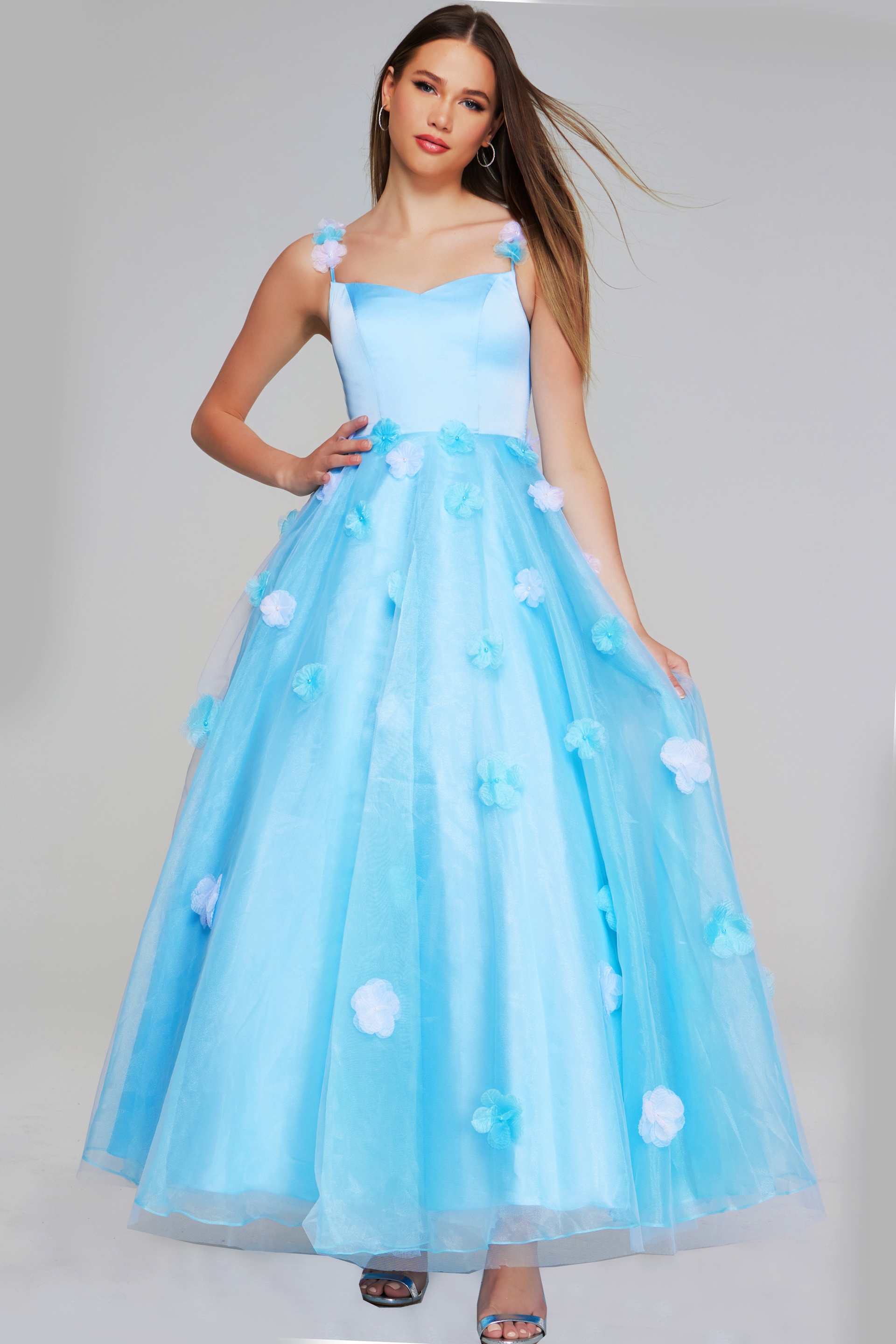 Model wearing Jovani K25988 light blue gown with floral appliques, front view.