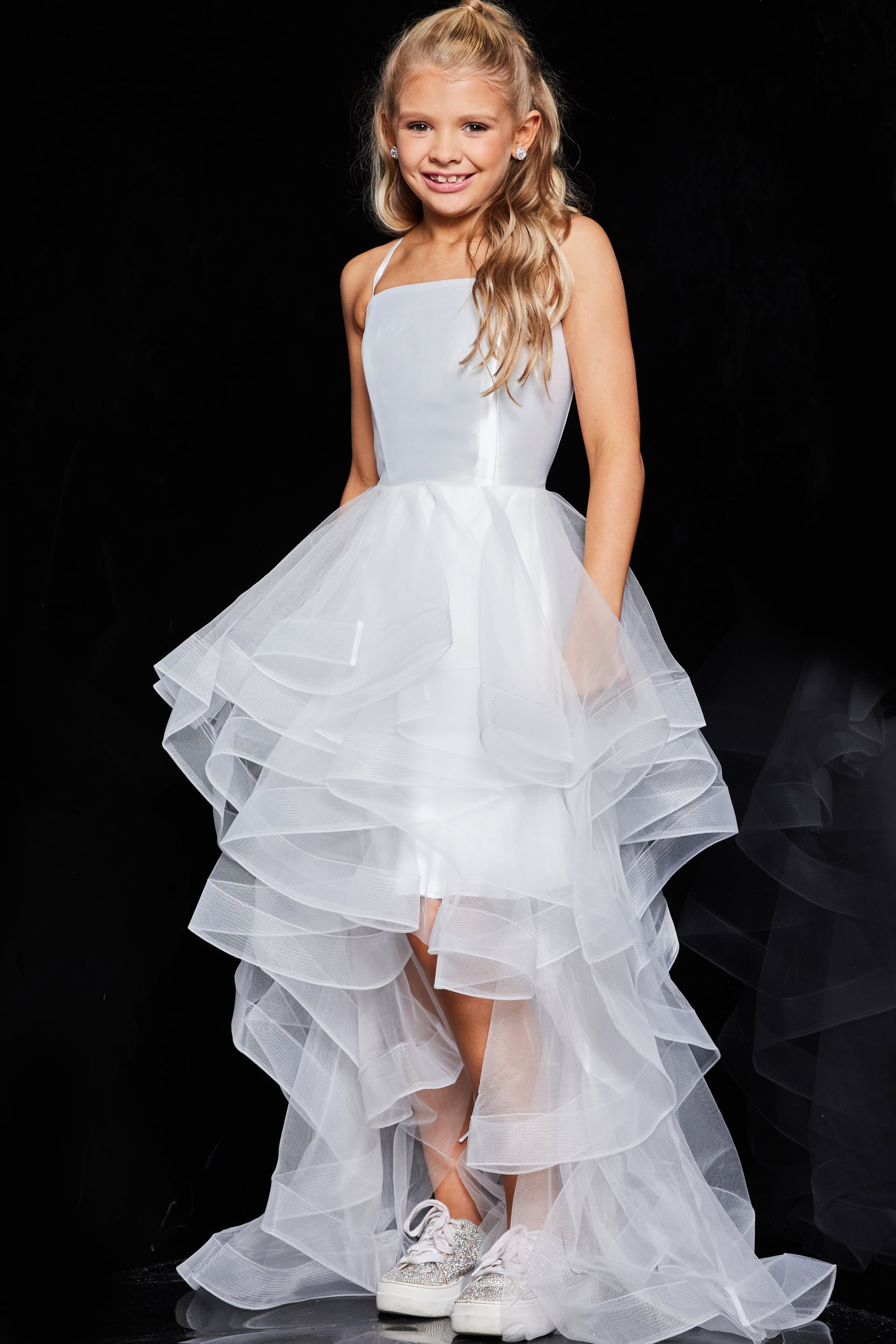 Model wearing Jovani K66708 white dress with square neckline and ruffled skirt.