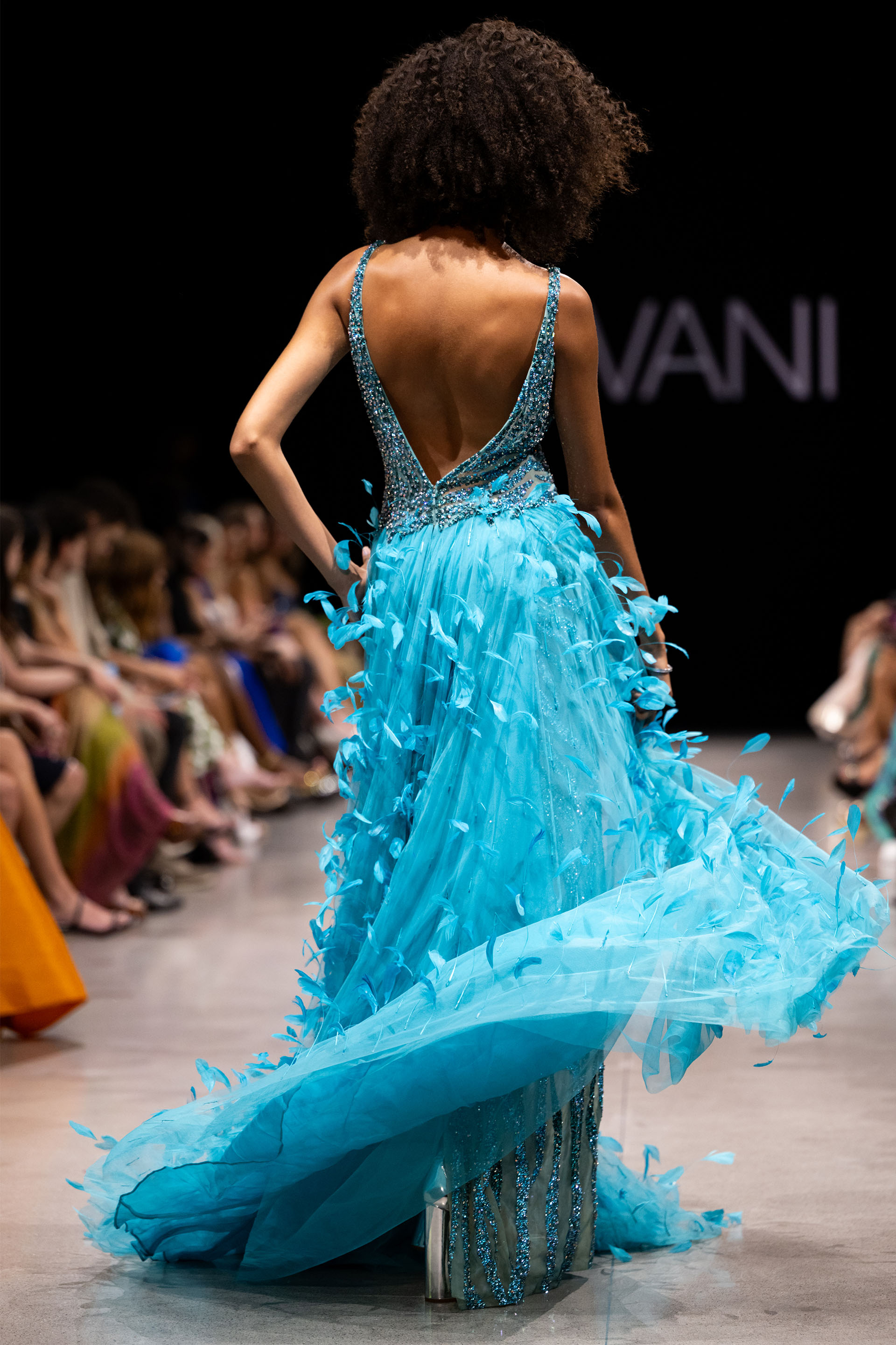 Model wearing Jovani S23074 blue sequin gown with V-neckline and high slit.