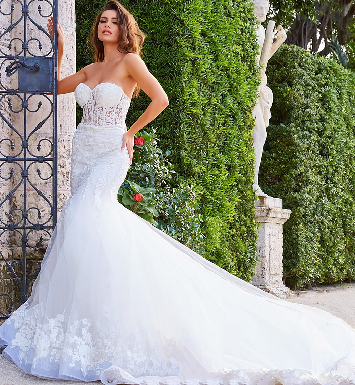 Model posing in Jovani JB07260 white dress, featuring a mermaid silhouette and intricate lace design