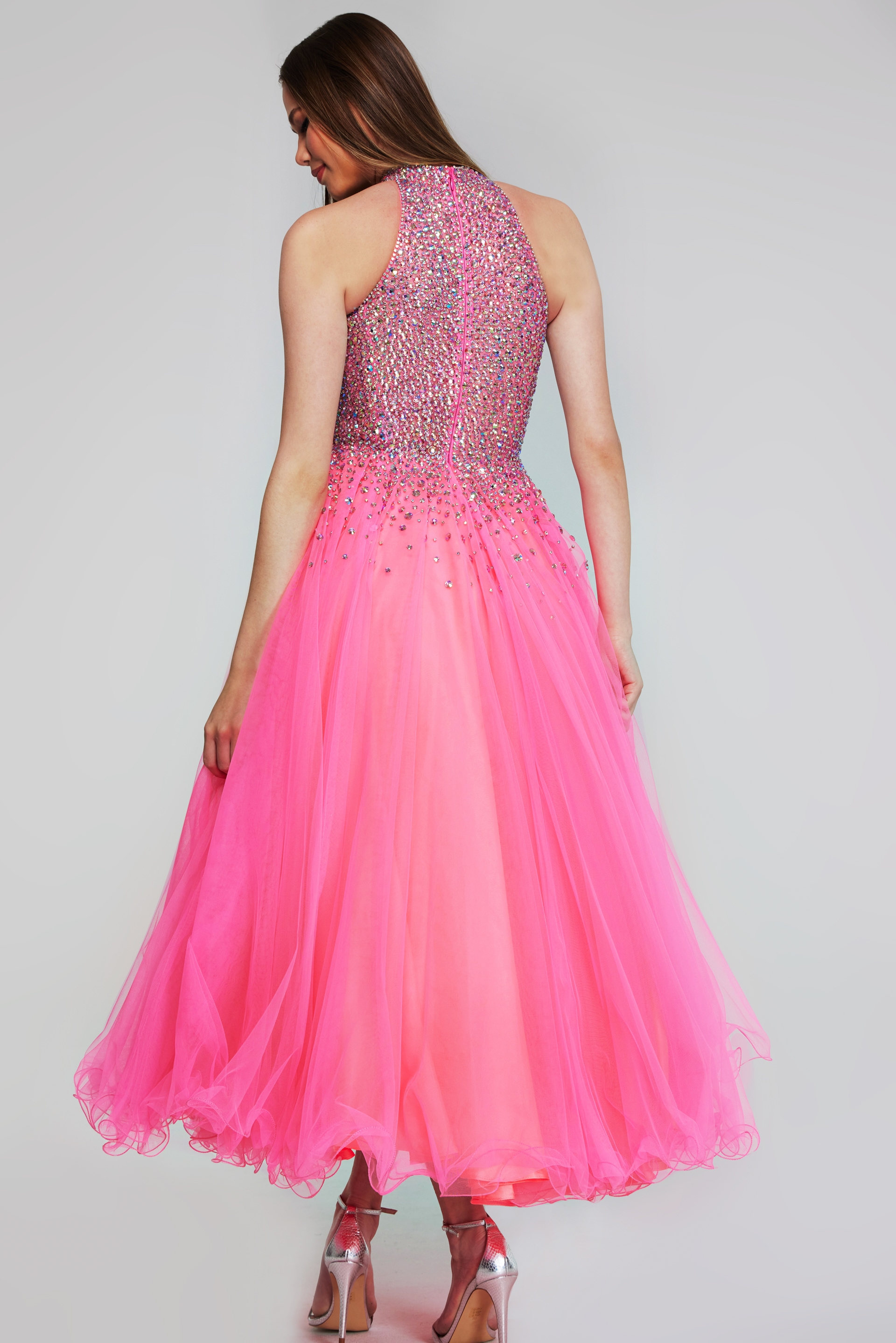 Back view of model wearing k38284 hot pink dress, featuring an embellished bodice and voluminous skirt.